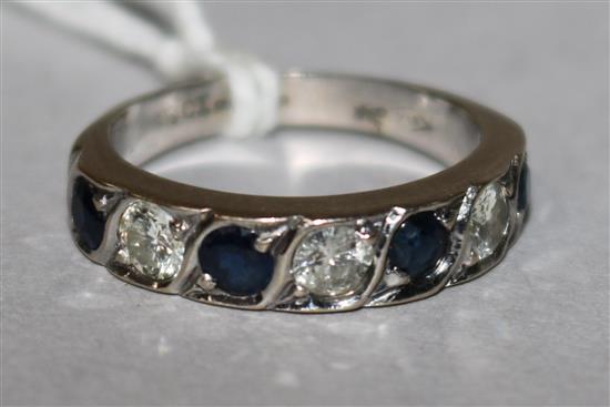 A 18ct white gold seven stone sapphire and diamond half hoop ring, size M.